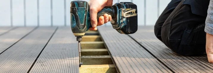 Person verschraubt WPC-Dielen mit Akkuschrauber